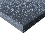 Close-up of a black rubber mat with white flecks on a white background