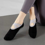 Black and gray yoga socks worn by a person on a gray surface