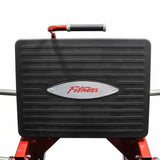 Close-up of black leg press platform with red Fitness logo on red and silver gym equipment