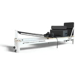 SuperAlphago Pilates reformer machine with black cushions and resistance bands on white background