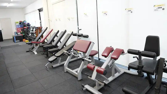 Row of strength machines lined up as commercial gym equipment in a fitness facility.