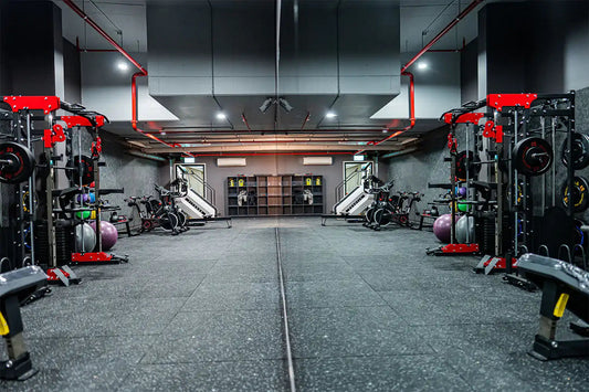 Modern gym interior with weight racks, exercise bikes, stability balls, and rubber flooring