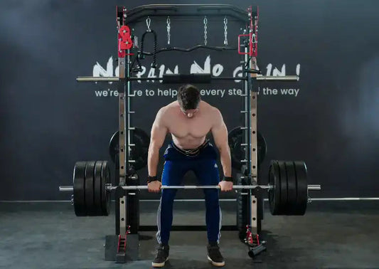 Man performing deadlift using a smith machine with heavy barbell plates in a gym setting.
