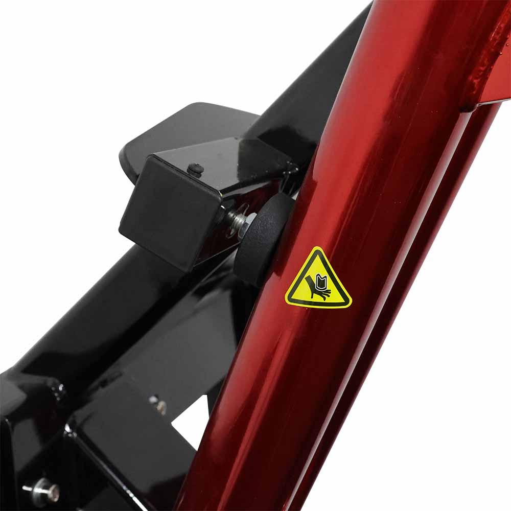 Close-up of chest press machine frame with a black bracket and warning triangle sticker on a white background indicating potential pinch hazard.