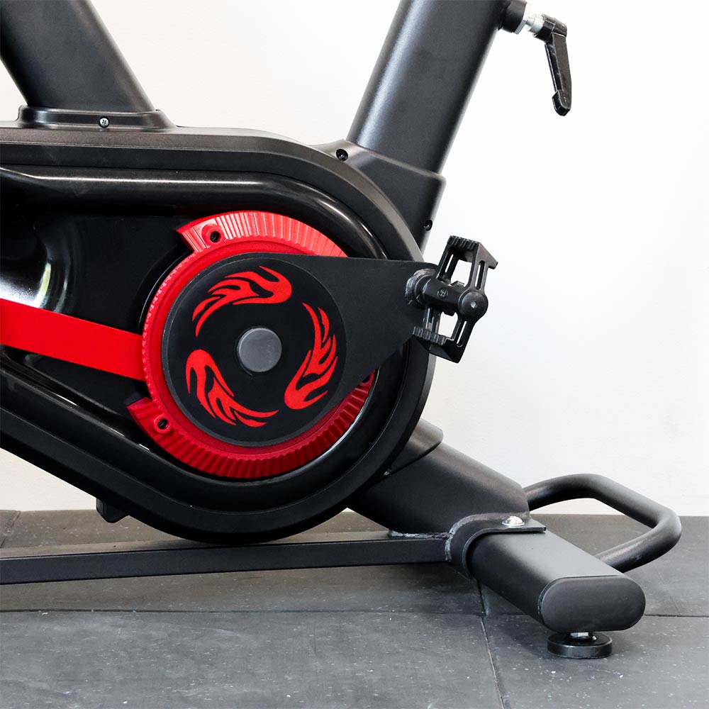 Close-up of a black and red exercise bike pedal with a white background
